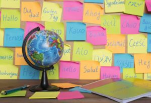 Hello written on different coloured post-it notes behind a globe.