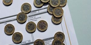 Photo of coins on a pay slip highlighting national insurance increase. 