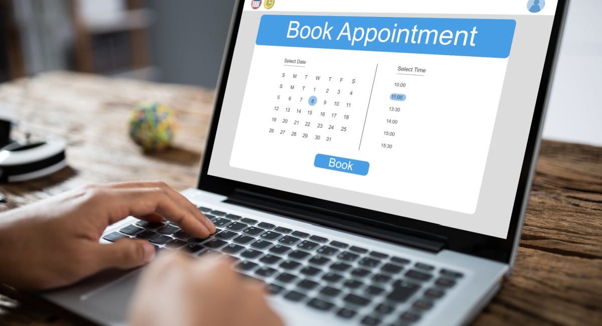 A laptop screen displaying an online scheduling system