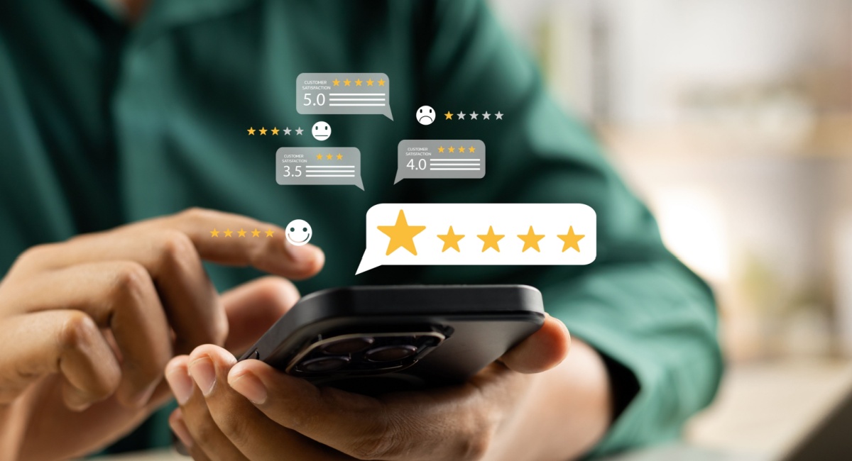 A person navigating their phone with illustrated icons floating above, showing customer satisfaction with star ratings and reviews